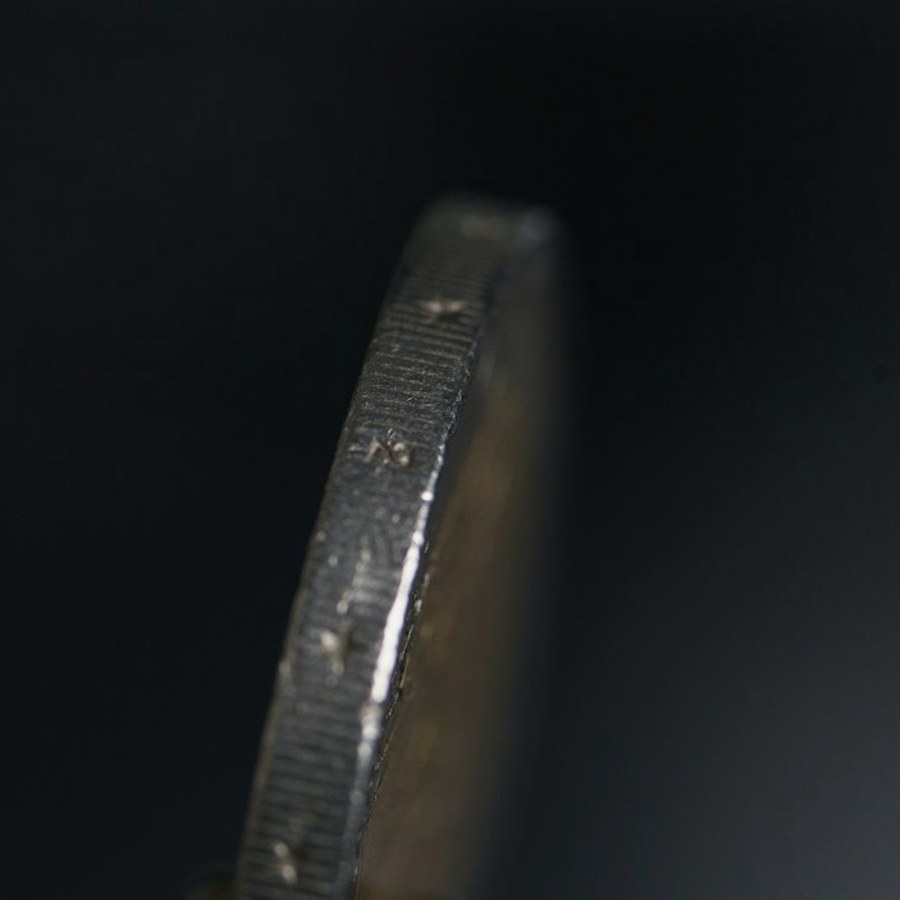 Close view of a table rail with stacked tokens and a card shoe