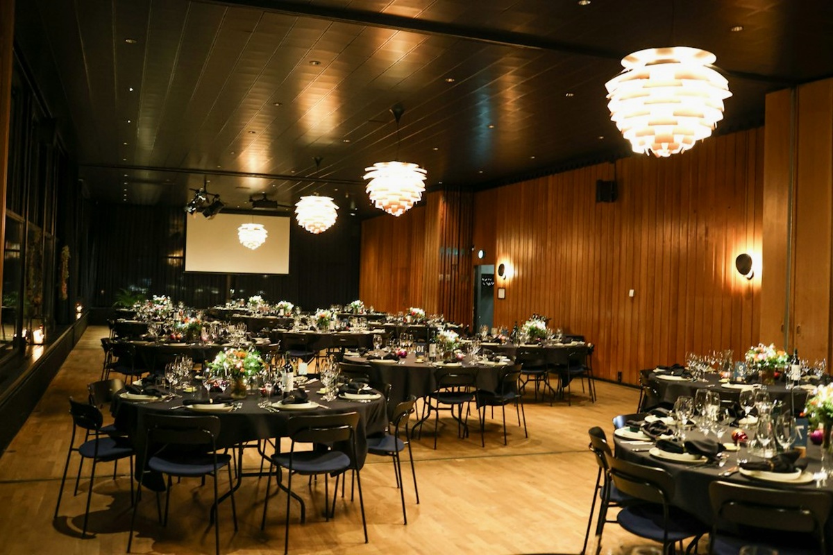 Stage with warm uplighting and a long dressed dinner table in a gala room