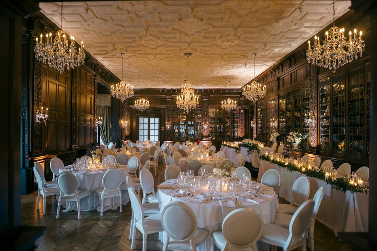 Gala stage with a lit backdrop, lectern and dressed round tables in front