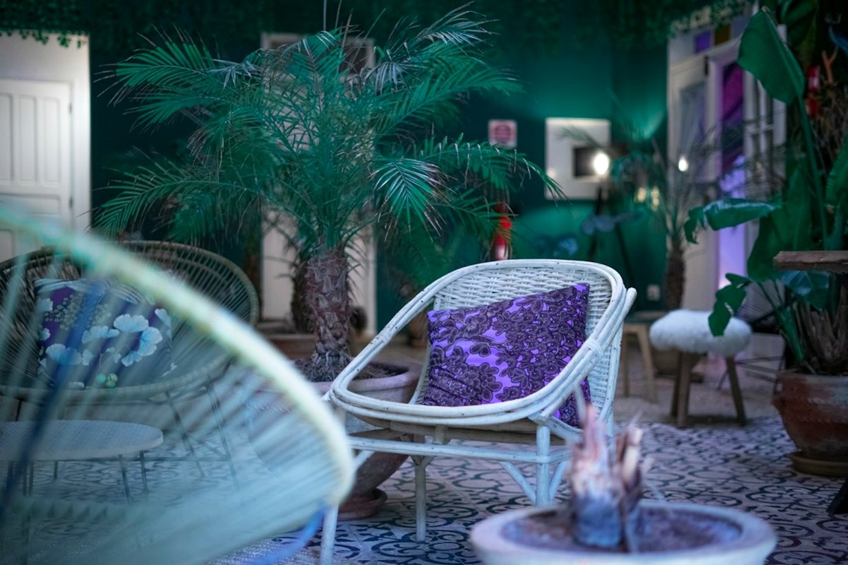 Palms, rattan lounge seating and lanterns arranged for a tropical evening